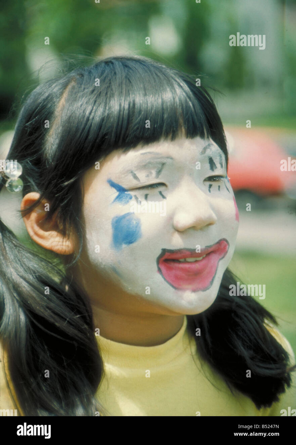 Asian girl in clown face makeup. St